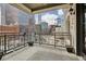 City views from private balcony with black metal railings, decorative lighting, and wood style floor tiling at 1827 N Grant St # 502, Denver, CO 80203