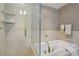 Elegant bathroom featuring a glass-enclosed shower and separate soaking tub with tile surround at 1827 N Grant St # 502, Denver, CO 80203