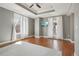 Cozy bedroom with tray ceiling, ceiling fan, TV, and natural light streaming in through sheer curtains at 1827 N Grant St # 502, Denver, CO 80203