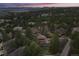 Expansive aerial view showcasing a luxurious home nestled within a lush, wooded community and mountain backdrop at 4406 Orofino Pl, Castle Rock, CO 80108