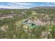 Scenic aerial view of a golf course community with a beautiful pond, surrounded by lush greenery and mature trees at 4406 Orofino Pl, Castle Rock, CO 80108