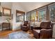 Cozy sitting area features two leather chairs, hardwood floors, and bright natural light at 4406 Orofino Pl, Castle Rock, CO 80108