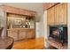 Cozy living area with built-in wood cabinets, hardwood flooring, and a brick fireplace at 4406 Orofino Pl, Castle Rock, CO 80108