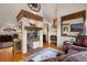 Inviting living room features a brick fireplace, hardwood floors, and comfortable leather seating at 4406 Orofino Pl, Castle Rock, CO 80108