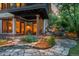 Inviting outdoor patio with stone flooring, exterior lighting, and lush landscaping, perfect for evening relaxation at 4406 Orofino Pl, Castle Rock, CO 80108