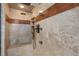 Luxurious stone shower featuring dual shower heads, a built-in bench, and recessed shelving at 4406 Orofino Pl, Castle Rock, CO 80108