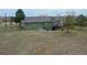 An expansive, empty backyard slopes down from the back of a green two-story home at 12337 2Nd St, Parker, CO 80134