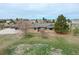 A single-story ranch style home with a long driveway, mature landscaping, and blue sky in the background at 12337 2Nd St, Parker, CO 80134