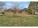 Ranch-style home with brick and green siding, set on a spacious grassy lot under a blue sky at 12337 2Nd St, Parker, CO 80134