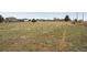 Wide-angle view of an expansive vacant lot with low grasses and sparse vegetation in a residential area at 12337 2Nd St, Parker, CO 80134