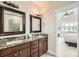 Bathroom featuring dual sinks, granite countertops, wood cabinets, and a glass-enclosed shower at 2838 Cascade Creek Dr, Lafayette, CO 80026