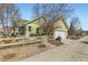 Charming exterior of home featuring green siding, a well-manicured yard, and a fenced-in area at 2838 Cascade Creek Dr, Lafayette, CO 80026