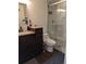 A bathroom featuring a shower, dark wooden cabinets and a marble-tiled shower at 7346 S Xenia Cir # A, Centennial, CO 80112