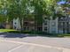 A multi-story apartment building with lush trees and a well-maintained lawn at 7346 S Xenia Cir # A, Centennial, CO 80112