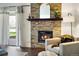 Close up of modern living room featuring a stone fireplace and gray accent chair at 7346 S Xenia Cir # A, Centennial, CO 80112