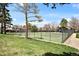 A fenced tennis court with grass and trees at 7346 S Xenia Cir # A, Centennial, CO 80112