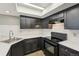 Modern kitchen with dark cabinetry, stainless steel sink, and bright countertop space at 5243 Union Ct # 4, Arvada, CO 80002