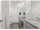 Bright bathroom featuring double vanity with granite counters, grey cabinets, and tiled shower at 968 Honey Berry Ct, Elizabeth, CO 80107