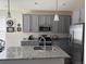 Modern kitchen featuring stainless steel appliances, granite countertops, an island sink and gray cabinets at 968 Honey Berry Ct, Elizabeth, CO 80107