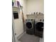 Bright laundry room featuring gray front-loading washer and dryer at 968 Honey Berry Ct, Elizabeth, CO 80107