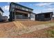 Green two-story home offers a cozy back porch and an unfinished backyard against a bright blue sky at 8581 Eckley St, Littleton, CO 80125