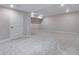Spacious basement with carpet floors, recessed lights, and door leading to hallway at 8581 Eckley St, Littleton, CO 80125