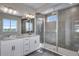 Modern bathroom with double vanity, granite countertop, and tiled glass shower at 8581 Eckley St, Littleton, CO 80125
