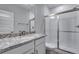 Bathroom featuring a granite vanity, a glass-enclosed shower, and sleek fixtures at 8581 Eckley St, Littleton, CO 80125