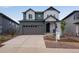 Inviting two-story home featuring mixed tone siding, a two-car garage, and meticulous landscaping at 8581 Eckley St, Littleton, CO 80125