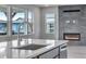 Modern kitchen with a large island, stainless steel faucet, and a fireplace feature wall at 8581 Eckley St, Littleton, CO 80125