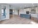 Open-concept kitchen and living area with modern appliances, a stylish fireplace, and hardwood floors at 8581 Eckley St, Littleton, CO 80125