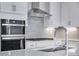 Modern kitchen featuring stainless steel appliances, white cabinetry, and sleek countertops at 8581 Eckley St, Littleton, CO 80125
