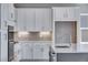 Well-equipped kitchen with white cabinets, stainless steel appliances, and stylish backsplash at 8581 Eckley St, Littleton, CO 80125