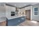 Modern kitchen boasts white cabinets, stainless steel appliances, and a large gray island at 8581 Eckley St, Littleton, CO 80125