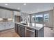 Bright kitchen with an island, hardwood floors, and large windows overlooking the neighborhood at 8581 Eckley St, Littleton, CO 80125