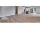 Open concept living room with light wood floors leading to the kitchen at 8581 Eckley St, Littleton, CO 80125