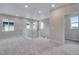 Open loft area with neutral carpet, staircase, and abundant natural light at 8581 Eckley St, Littleton, CO 80125
