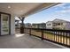 Covered outdoor porch with dark wood railings overlooking the backyard at 8581 Eckley St, Littleton, CO 80125