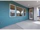 Outdoor porch with turquoise siding, large windows, and a glass door at 8581 Eckley St, Littleton, CO 80125