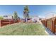 Spacious backyard with well-kept lawn, and a view of the house, trees and neighboring buildings at 11560 River Run Cir, Commerce City, CO 80640