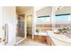 Well-lit bathroom with a glass-enclosed shower, soaking tub, and updated vanity at 11560 River Run Cir, Commerce City, CO 80640