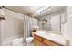 Bright bathroom featuring a tub with shower, updated vanity, and decorative accents at 11560 River Run Cir, Commerce City, CO 80640