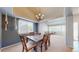 Cozy dining room with a chandelier, large windows, and a rustic wooden table at 11560 River Run Cir, Commerce City, CO 80640