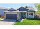Charming home featuring a two-car garage, stone accents and manicured lawn at 11560 River Run Cir, Commerce City, CO 80640