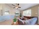 Cozy living room with a large sectional couch, ceiling fan, and natural light at 11560 River Run Cir, Commerce City, CO 80640
