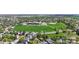 An aerial view of a quiet neighborhood, a school, a park and many green trees at 11560 River Run Cir, Commerce City, CO 80640