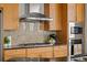 Kitchen with gas cooktop, microwave, and granite backsplash at 5455 Landmark Pl # 604, Greenwood Village, CO 80111