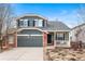 Charming two-story home featuring a landscaped front yard, a two-car garage, and a cozy front porch at 1461 Hickory Ct, Erie, CO 80516