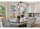 Eat-in kitchen with white cabinets, tile backsplash, stainless sink, and natural light pouring in from the windows at 1461 Hickory Ct, Erie, CO 80516