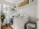 Bright laundry room with washer and dryer, and storage space on shelves at 1461 Hickory Ct, Erie, CO 80516